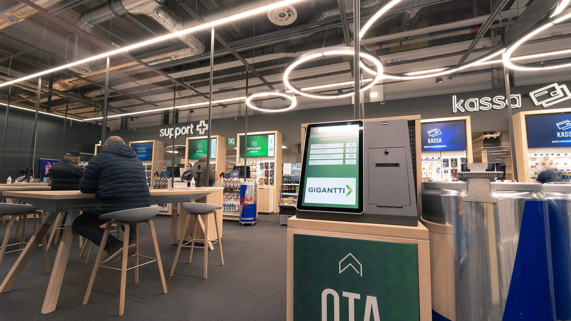 Asiakkaat odottavat vuoroaan rennosti Gigantti Megastore Vantaalla EWQ Jonottomien Palveluiden ansiosta.
